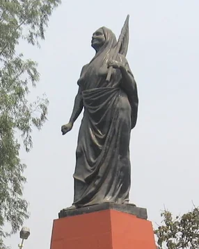 Bronze statue of Matangini Hazra on a red plinth in Kolkata, showing her standing with one arm outstretched.